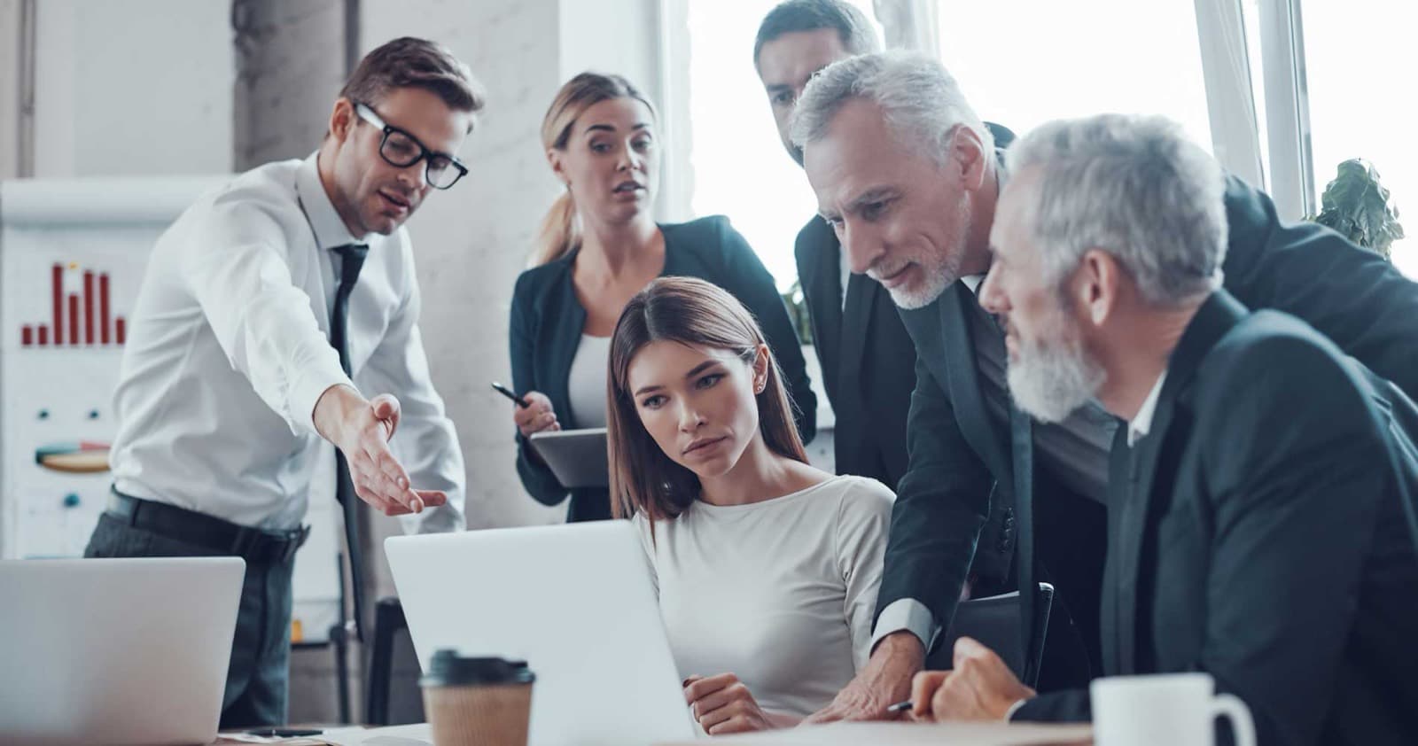 Business team gathered around a laptop reviewing a plan